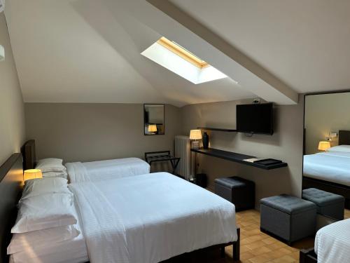 a hotel room with two beds and a skylight at Hotel Ristorante San Giuseppe in Cernobbio
