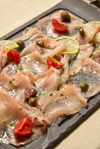 a plate of food with meat and tomatoes and olives at Le Maginot Relais in Castelvetro Piacentino