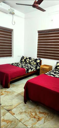 a bedroom with two beds and a ceiling at Ceebeez homes in Ernakulam