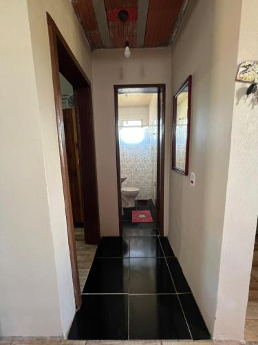 a hallway leading to a bathroom with a sink at Ótima casa de praia a 2 quadras do mar in Tramandaí