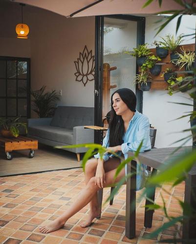 a woman sitting on a bench in a living room at Guané Glamping Ecolodge Jacuzzi Privado Oriente Antioqueño in Guarne