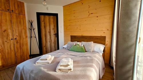 a bedroom with a bed with two towels on it at Willa Magdalena in Sromowce Niżne