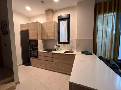 a kitchen with wooden cabinets and a counter top at Apartamentos Granada 76 in Nerja