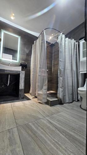 a bathroom with a shower with white curtains at casa Apodaca cerca del aeropuerto in Monterrey
