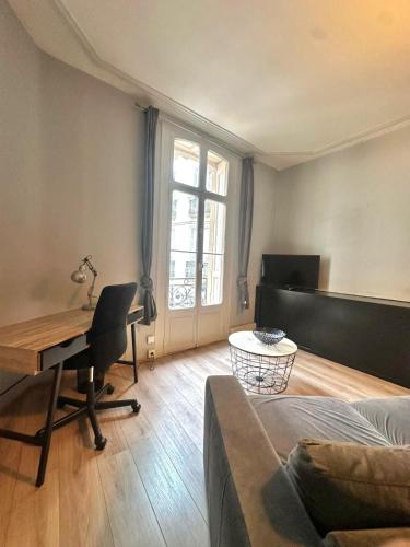 - un salon avec un bureau, un lit et une table dans l'établissement Charmant appartement en hyper centre, à Perpignan