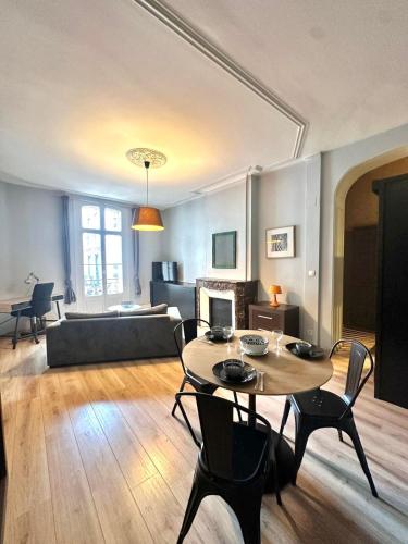 un salon avec une table, des chaises et un canapé dans l'établissement Charmant appartement en hyper centre, à Perpignan
