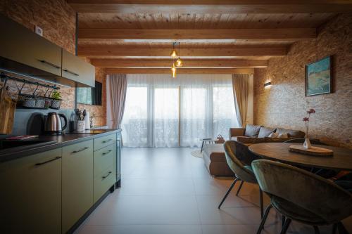 a kitchen and living room with a table and a couch at Green Valley Apartments in Zavrč