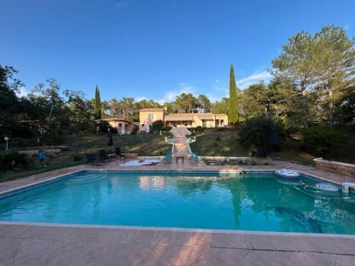 - une grande piscine avec une fontaine dans la cour dans l'établissement Villa proche Golfe de St Tropez, au Muy