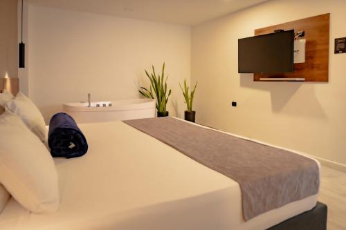 a bedroom with a bed with a tv on the wall at Fence by Bernalo Hotels in Medellín