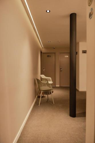 a waiting room with a bench and a pole at Fence by Bernalo Hotels in Medellín