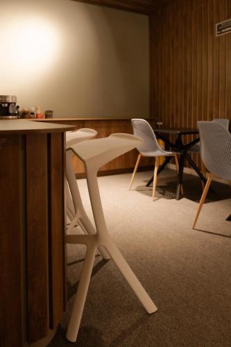 two white chairs and a table in a room at Fence by Bernalo Hotels in Medellín