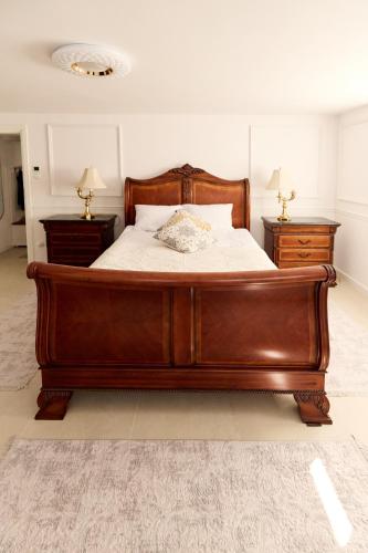 a large wooden bed in a bedroom with two night stands at Winnica Zagrody-Stanislaw Majkut in Gwizdów