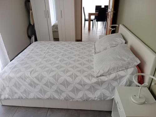 un lit avec des draps blancs et des oreillers dans une chambre dans l'établissement Maison Dominique, à Balzac