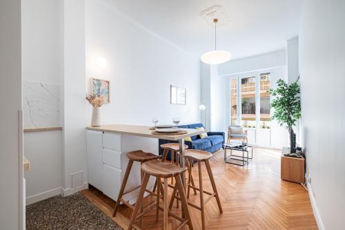 - une cuisine blanche avec une table et des tabourets dans l'établissement 10 AMIRAL 201 - Magnifique apt - 2 chambres - Centre-ville, à Nice