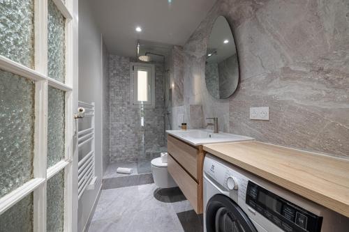 une salle de bain avec un lavabo et une machine à laver dans l'établissement 10 AMIRAL 201 - Magnifique apt - 2 chambres - Centre-ville, à Nice
