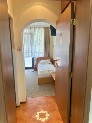a room with a bedroom with a bed and an open door at Daf Trans Hotel in Peshtera