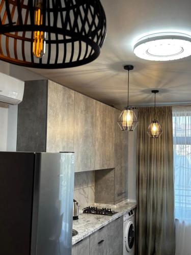 a kitchen with a refrigerator and two pendant lights at Apartments Black Sea in Odesa