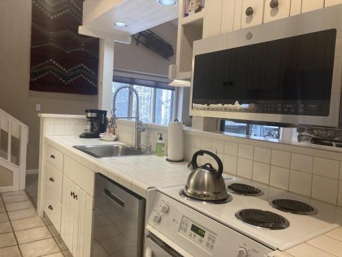 a kitchen with a stove and a tea kettle at Moose Creek Lodge in Wilson