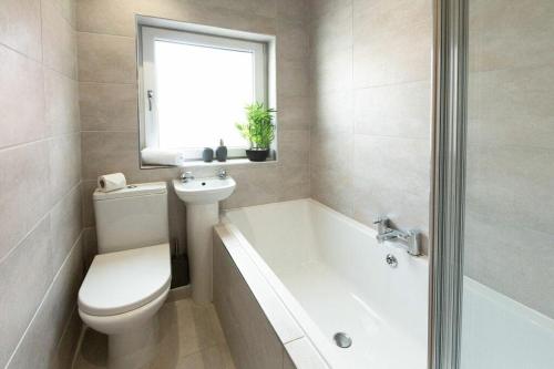a bathroom with a toilet and a tub and a sink at 1 Bed Cottage With Hot Tub Great Ayton - TOP Cottage in Great Ayton
