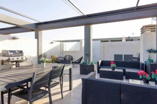 Un patio al aire libre con una mesa y sillas de madera. en Bungalow Pink Oasis - Winter by the Sea, en Alicante