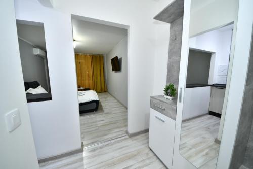 a small apartment with white walls and a mirror at Sco Studio in Galaţi