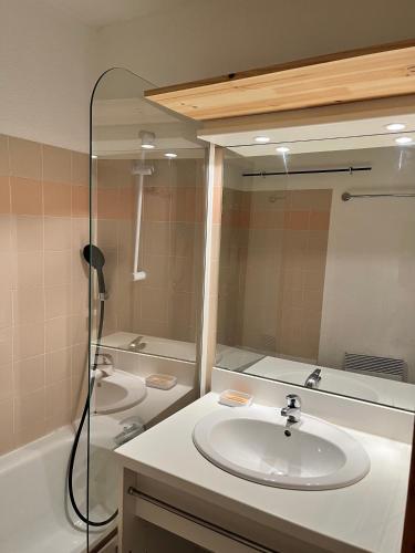 une salle de bain avec un lavabo, une baignoire et un miroir dans l'établissement Appartement 6 personnes au pied des pistes - Ecrin des Neiges 205, à Valmeinier