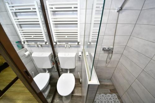 a bathroom with two toilets and a shower at Cornelius Studio in Galaţi