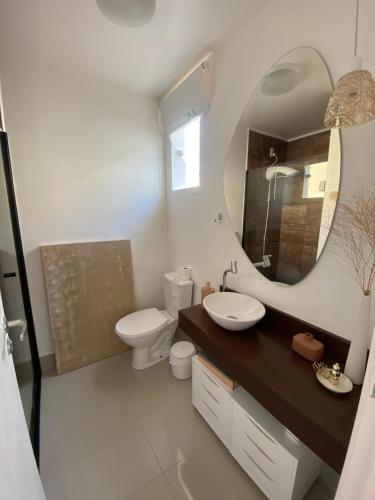 ein Badezimmer mit Waschbecken, Spiegel und Toilette in der Unterkunft Casa de férias in Balneário Camboriú