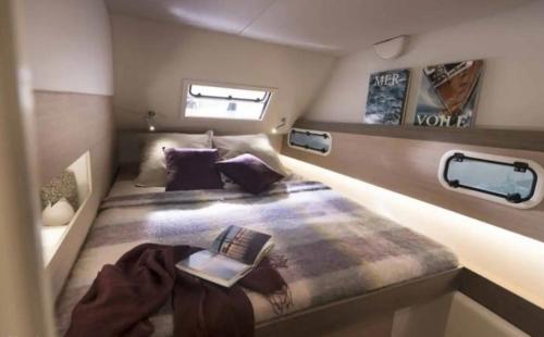 a small bedroom with a bed with a book on it at Centro Ibiza Catamaranes y Velero in Ibiza Town