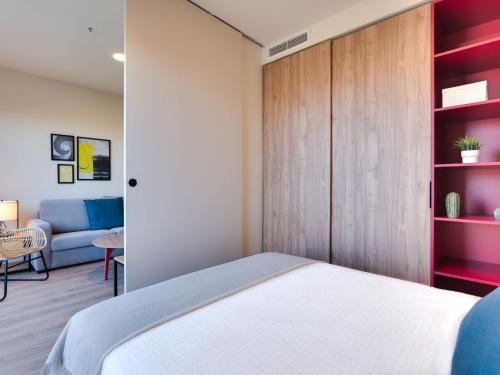 a bedroom with a bed and a couch at Livensa Living Studios Madrid Alcobendas in Alcobendas