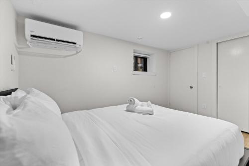 a white bed with a pair of shoes sitting on it at Spacious NW Apt Steps to 14th Street Corridor in Washington, D.C.