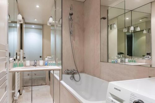 a bathroom with a tub and two sinks and a shower at Foch triomphe in Paris