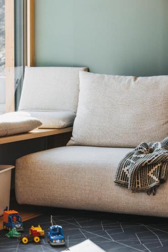 a couch with two pillows and toy cars on the floor at Hus154 Ferienhaus im Brandnertal in Bürserberg