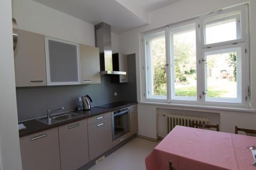 a kitchen with white cabinets and a sink and a window at Pension Karnet in Prague