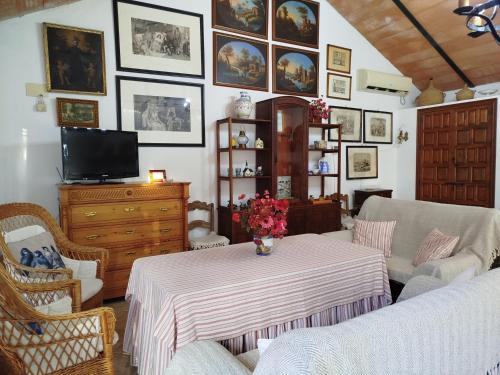 a living room with a table and a tv at Casa Rural del Guadalora in Hornachuelos