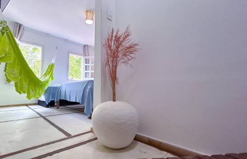 a white vase with a plant in a room at Casarão Jeri in Jericoacoara