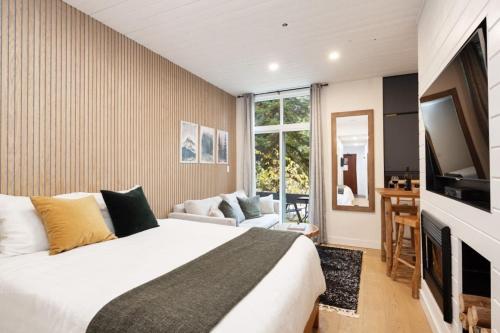 a bedroom with a bed and a flat screen tv at Cozy Cabin Vibes at Glacier Lodge in Whistler