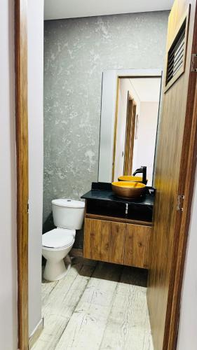 a bathroom with a sink and a toilet and a mirror at Vivanti Resort in Guatapé