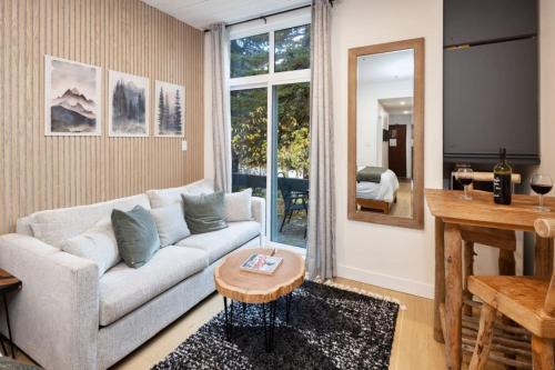 a living room with a couch and a table at Cozy Cabin Vibes at Glacier Lodge in Whistler