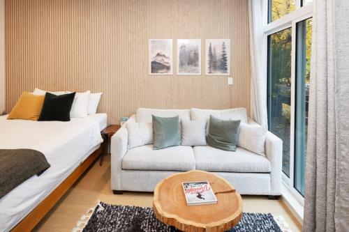 a living room with a couch and a coffee table at Cozy Cabin Vibes at Glacier Lodge in Whistler