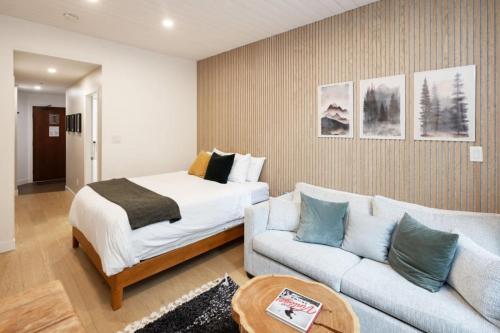 a bedroom with a bed and a couch at Cozy Cabin Vibes at Glacier Lodge in Whistler