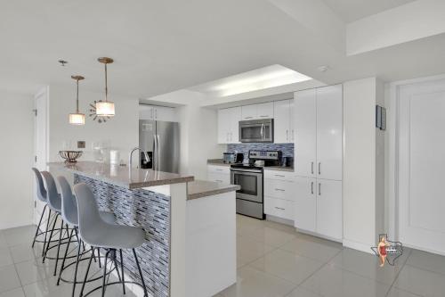 a kitchen with white cabinets and a counter with bar stools at Bahia Mar-Solare Tower, Beachfront Resort with Two Pools in South Padre Island