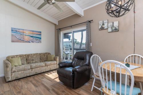 ein Wohnzimmer mit Sofa und Tisch in der Unterkunft Tiki 250 in South Padre Island