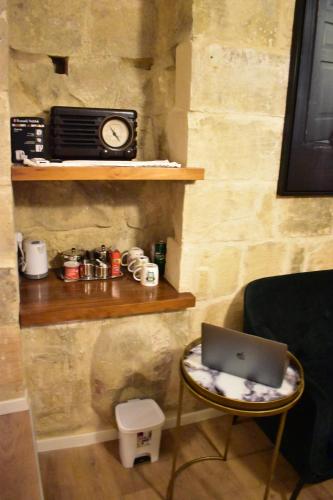 a laptop sitting on a chair with a clock on a wall at Grand Arcanum Apartment 2 - Comfortable and Elegant in Senglea