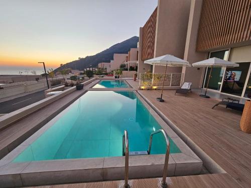 a swimming pool in front of a building at Villa Champagne Green Coast Palase in Palasë