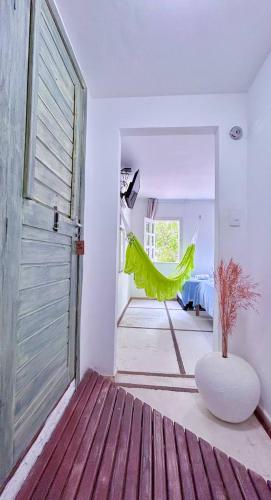 a room with a door and a green hammock in it at Casarão Jeri in Jericoacoara