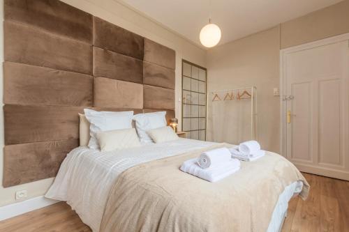 a bedroom with a large bed with towels on it at Le Green Lodge in Faches-Thumesnil