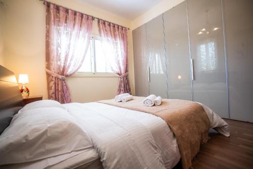 a bedroom with a large bed with towels on it at Beachfront Villa Larnaka Dhekelia with Pool in Pyla