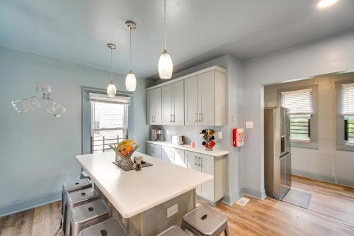 a kitchen with blue walls and white cabinets and a kitchen island at 4 Mi to Dtwn Home with Patio in Cleveland! in Cleveland