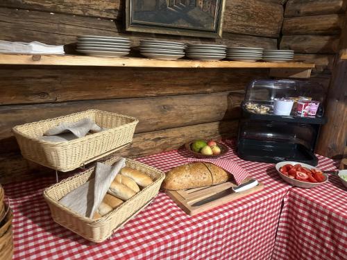 a table with baskets of bread and apples on it at Gazdovský dvor B&B s Mini Wellness in Bešeňová